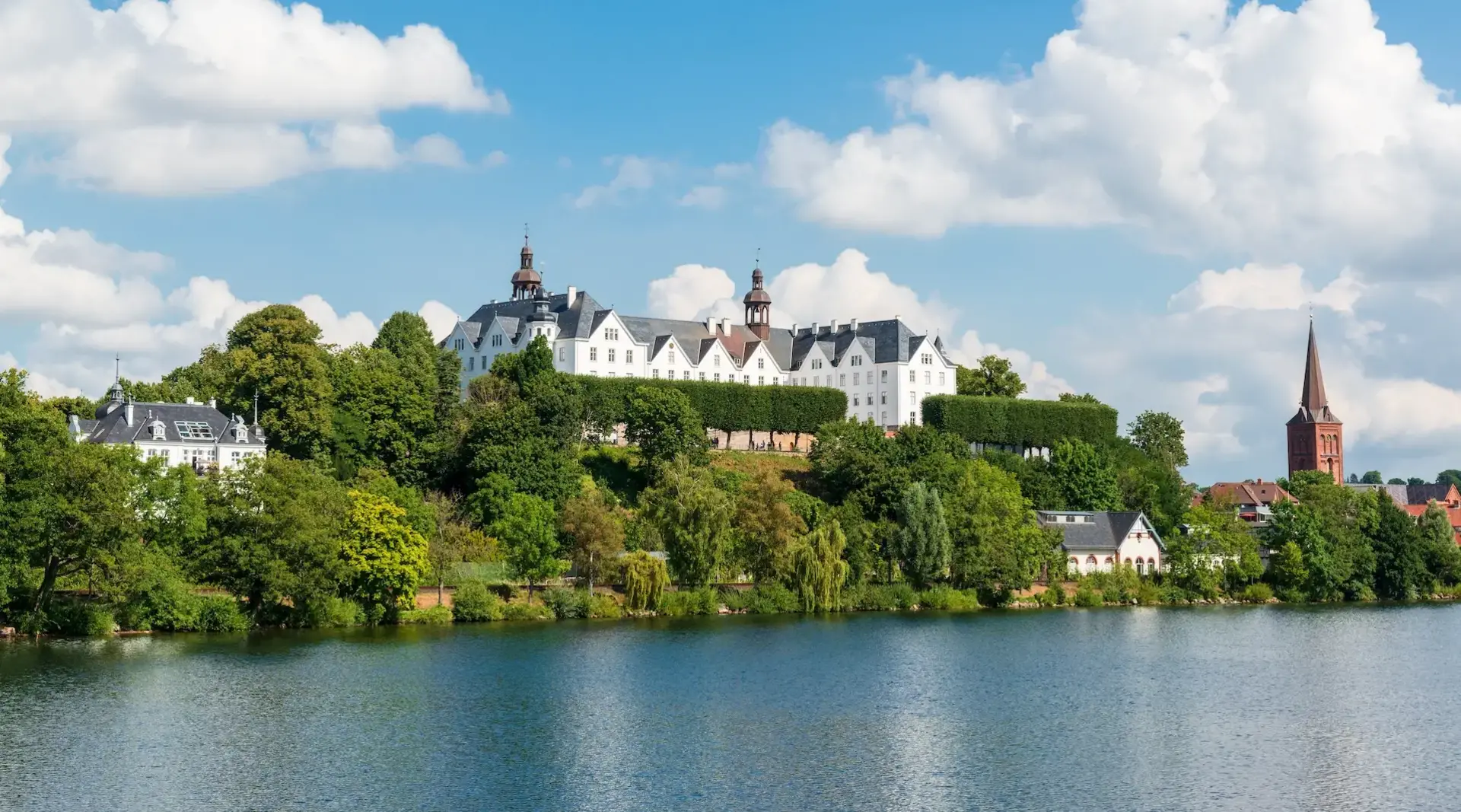 Plöner Schloss vom Wasser - Ausflugsziel beim Bauernhof-Urlaub - © penofoto.de, AdobeStock Fotos einer Bootsfahrt auf dem Großen Plöner See ein unter Naturschutz stehender See in Schleswig-Holstein.