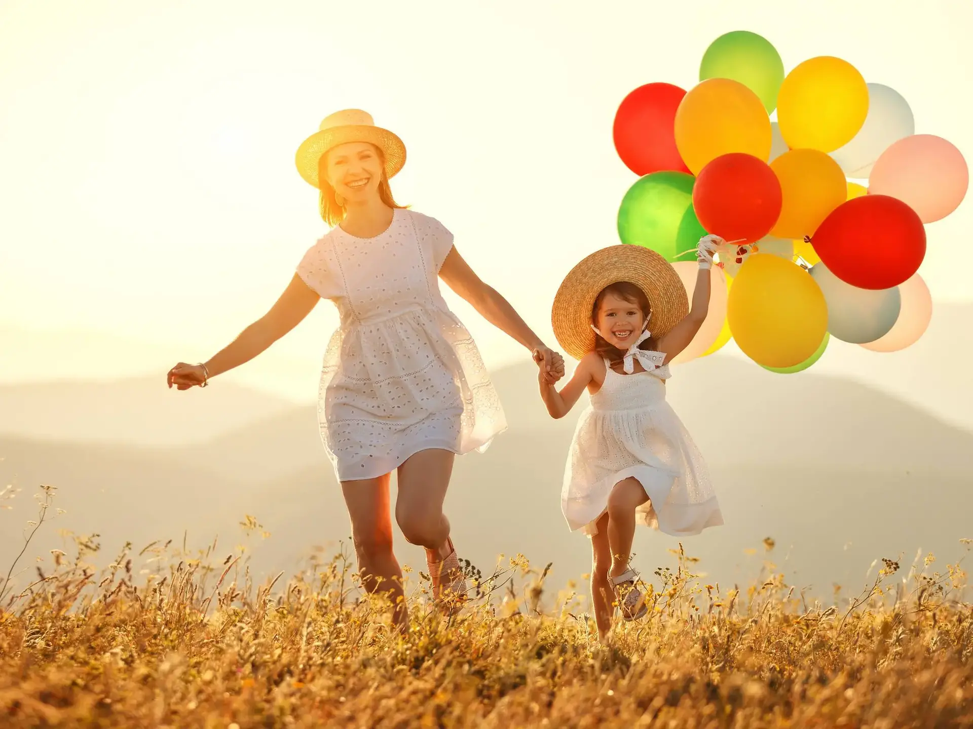 happy family mother and child with balloons at sunset in summer happy family mother and child daughter with balloons at sunset in summer