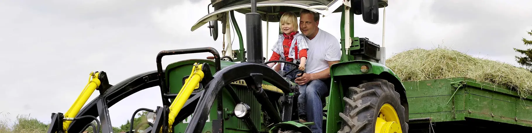 Bei einem Urlaub auf dem Bauernhof in Thüringen können Kinder auf dem Traktor mitfahren.