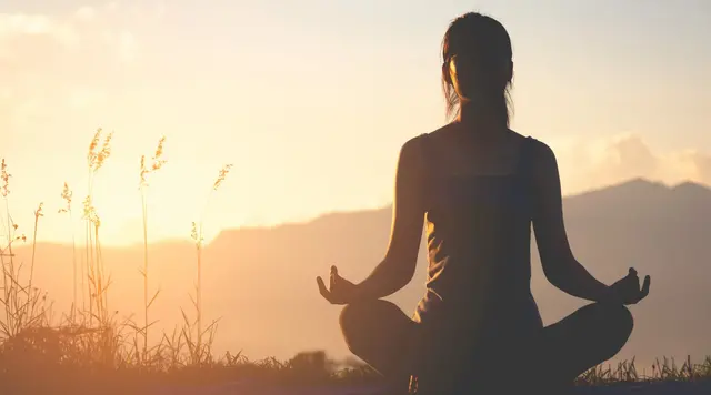 Zeit für Ruhe und Entspannung auf dem Land - © nakedcm, adobe stock Person meditiert in der Natur bei Sonnenuntergang