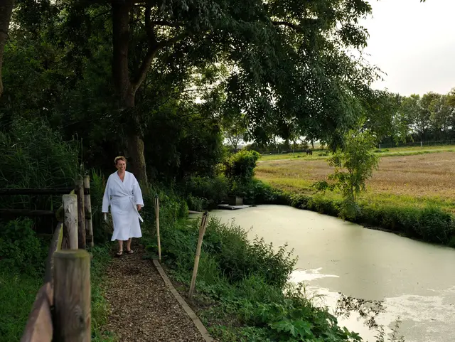 Frau läuft zu Fluss im Bademantel