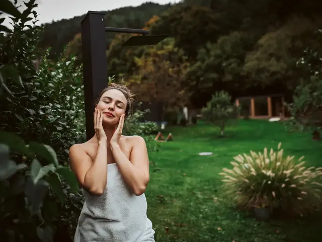 Wellnessurlaub auf dem Land – Entspannung nach der Sauna im Garten - © Halfpoint, AdobeStock Frau entspannt im Garten nach einem Saunagang während eines Wellnessurlaubs auf dem Land