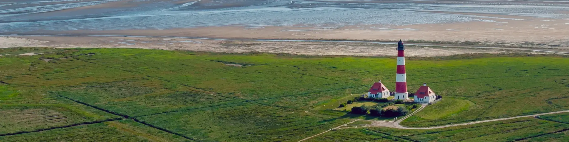 Blick über die Salzwiesen auf die Nordsee mit dem Leuchtturm von Westerhever, Schleswig-Holstein