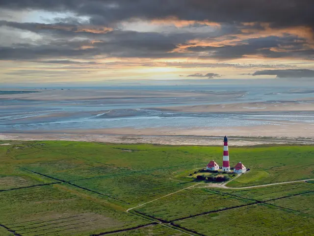 Blick über die Salzwiesen auf die Nordsee mit dem Leuchtturm von Westerhever, Schleswig-Holstein