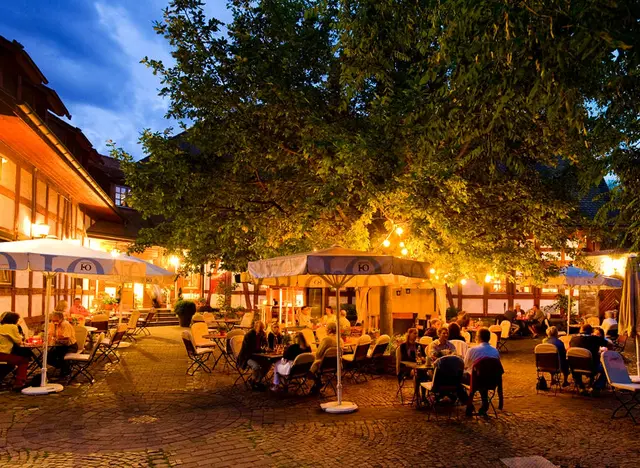 Den Tag genussvoll ausklingen lassen - © Rheinland-Pfalz Tourismus GmbH, Dominik Ketz Gäste sitzen am Abend in einer Straußwirtschaft in Köngernheim und genießen regionale Weine während eines Urlaubs auf dem Weingut in Rheinhessen.