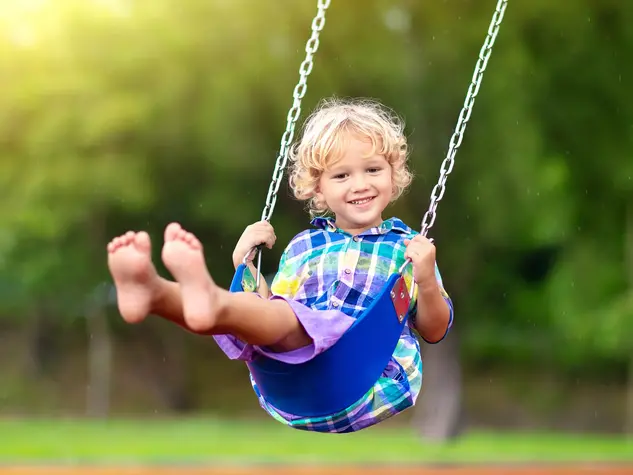 im Urlaub auf dem Kinderhof toben die Kinder auf dem Spielplatz