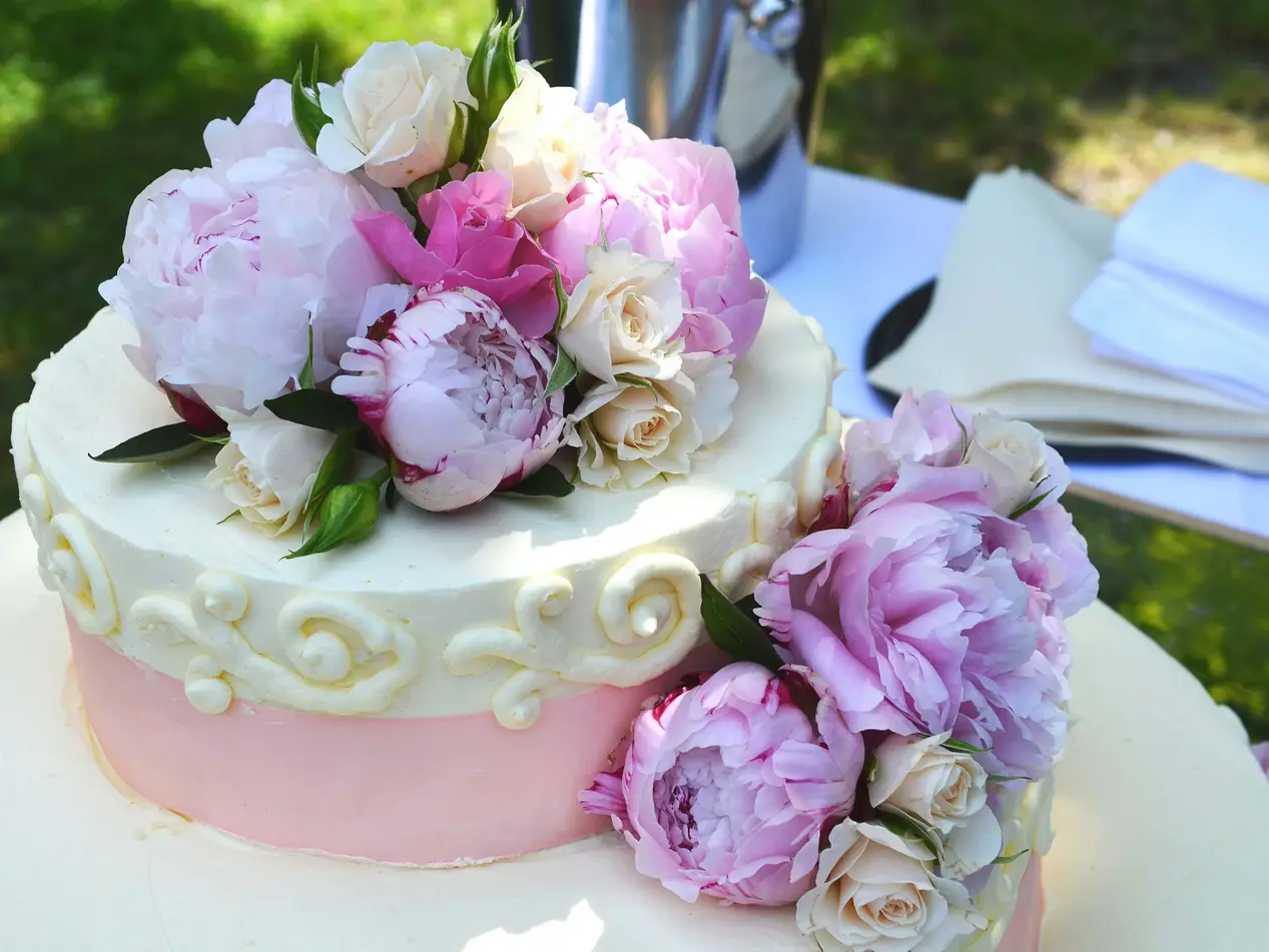 Hochzeitstorte mit Blumen im Garten auf dem Weingut