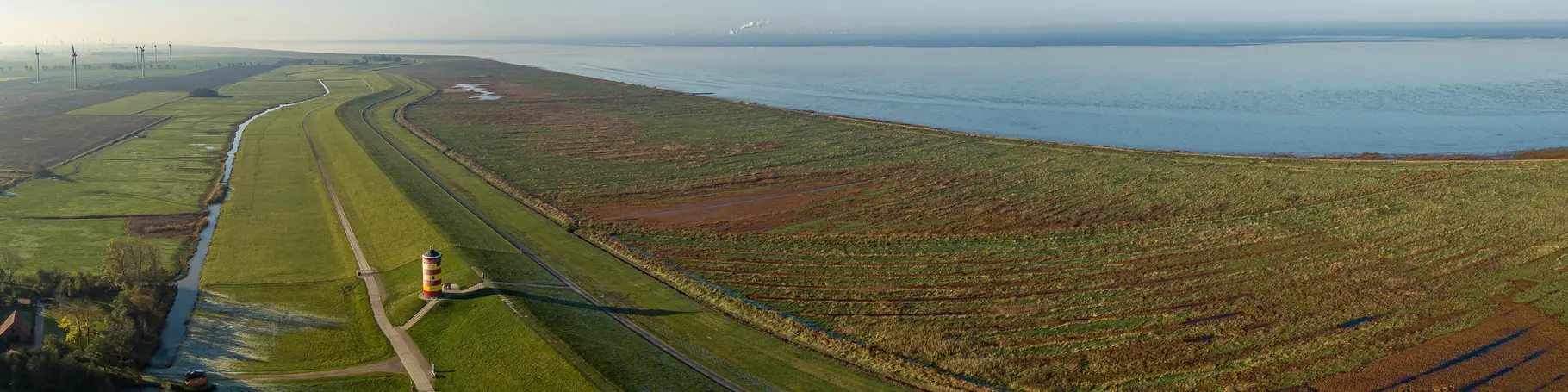 Blick von oben auf den Nordseedeich mit dem Pilsumer Leuchtturm, Ostfriesland