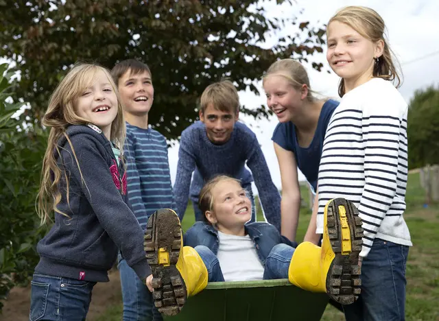 im Urlaub auf dem Bauernhof in Schleswig-Holstein helfen die Kinder bei der Stallarbeit