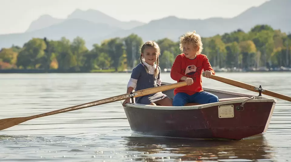 im Familienurlaub auf dem Bauernhof am Chiemsee entdecken Kinder im Ruderboot den See