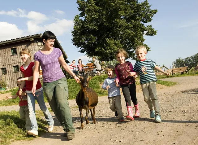 Kinder helfen bei der Stallarbeit und beim Füttern der Tiere