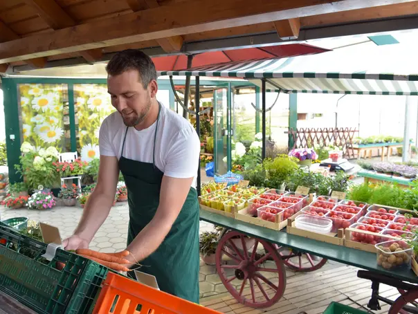 biohof mit Hofladen - Verkauf und Handel von frischem Bio Obst und Gemüse beim Erzeuger - Mann verkauft // biohof with farm shop - sale and trade of fresh organic fruit and vegetables at the grower