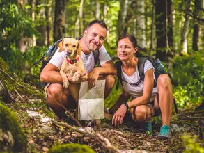 Wanderer mit Hund im Wald - © kerkezz / AdobeStock Wanderer machen eine Wadertour mit ihrem Hund